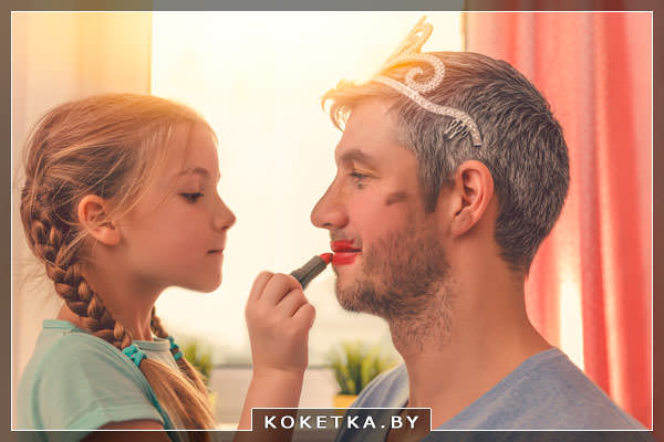 Папа играет с дочерью и дает ей накрасить себя