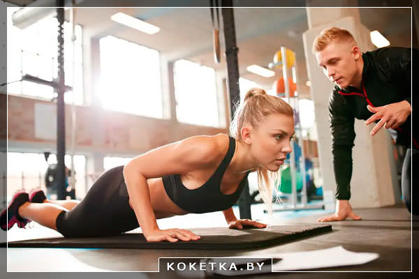 тренер консультирует девушку в фитнес центре
